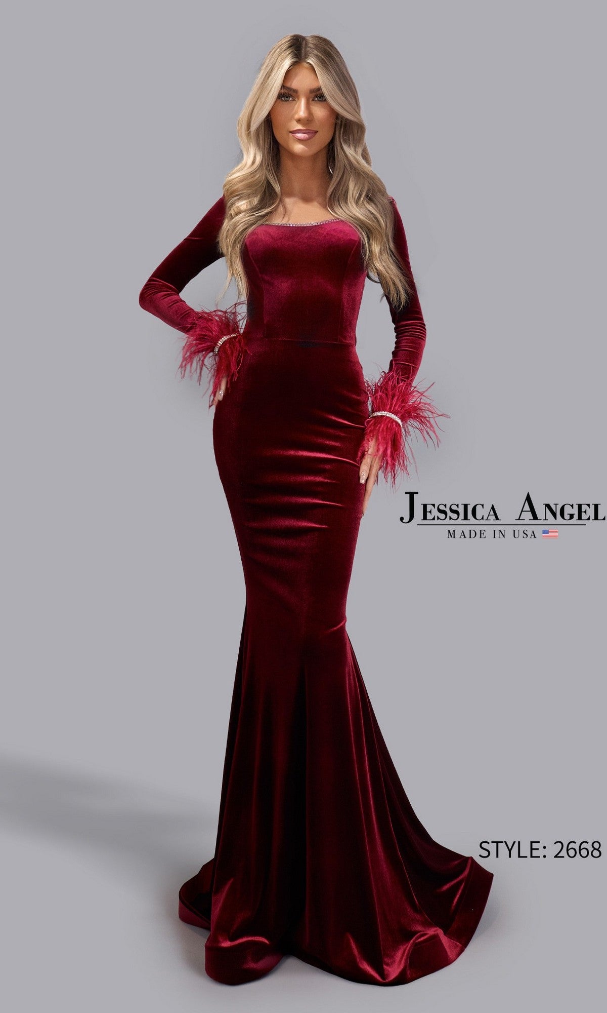 A woman in a long, fitted wine velvet Jessica Angel 2668 prom dress with feathered cuffs stands before a plain gray background.